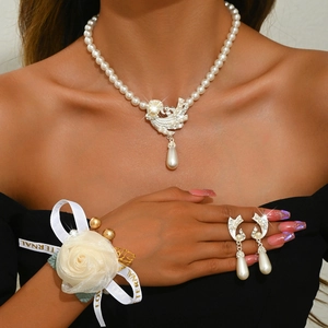 Detailed bridal jewelry set with floral phoenix pendant and lace rose wrist corsage