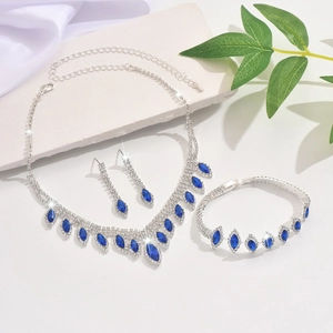 Detailed view of silver wedding jewelry set with navy blue stones on stone background
