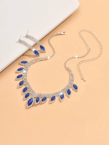 Detail of bridal jewelry set with navy blue marquise stones and crystals on warm background