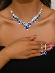 Detailed view of silver wedding necklace and blue gemstone earrings on a model