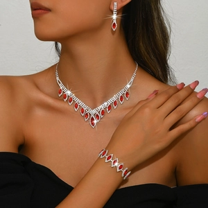Close-up of sparkling bridal jewelry set with red gemstones on an elegant model