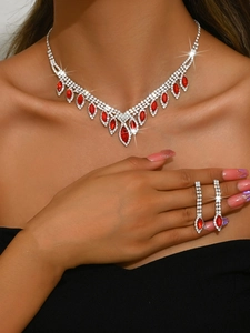 Detail of bridal jewelry set with red marquise gems and crystals on a model