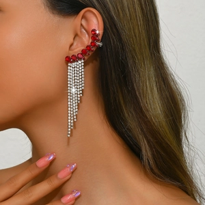 Close-up of silver tassel ear clip with red teardrop stones and sparkling rhinestones