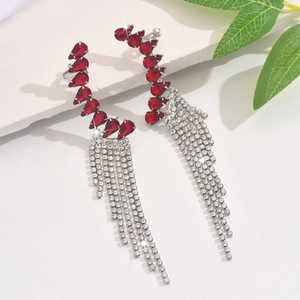 Close-up of red pear-shaped gemstone fringe earrings with silver cascading tassels