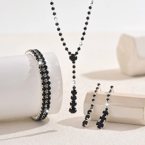 Detailed view of elegant black crystal necklace, bracelet and earrings on props