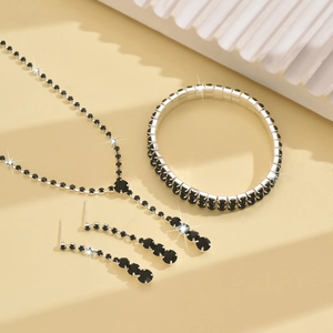 Detail shot of elegant silver necklace, bracelet and earrings set with black crystals