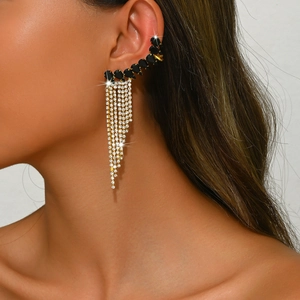 Close-up of silver tassel ear cuff with black gemstones and sparkling rhinestones