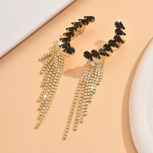 Close-up of tassel earrings with black teardrop gems and sparkling rhinestone fringe