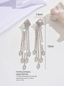 Detailed view of silver long tassel earrings with sparkling rhinestones and hollow leaves