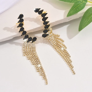 Macro detail of luxury long tassel earrings with black gemstones and sparkling rhinestones