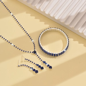 Close-up of elegant V-shaped necklace, bracelet and drop earrings set with deep blue crystals