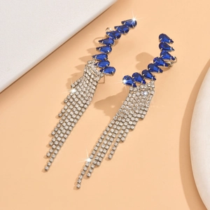Detailed view of silver tassel earrings with dark blue teardrop rhinestones and dangling chains