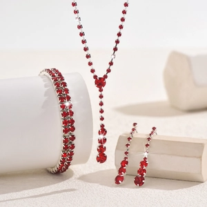 Detailed view of elegant bridal jewelry set with red rhinestones and silver metal finish