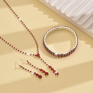 Detailed view of Y-shaped necklace with red crystals and matching silver earrings