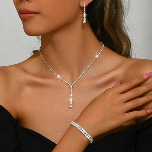 Elegant silver wedding jewelry set featuring rhinestone necklace, earrings, and bracelet
