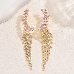 Detailed macro view of pink waterdrop gemstones and long golden tassel earrings