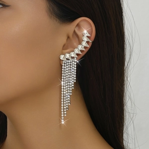 Close-up of sparkling rhinestone tassel ear cuff on female model with starburst highlights