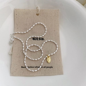 Silberne Perlenkette mit goldenem LOVE Anhänger auf einer beigen Displaykarte präsentiert