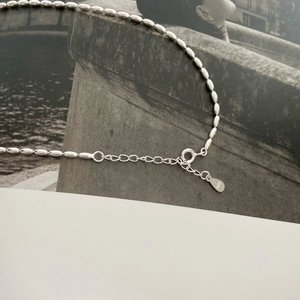 Makroaufnahme einer S925 Sterlingsilber-Reisperlenkette mit Punze und Federringverschluss