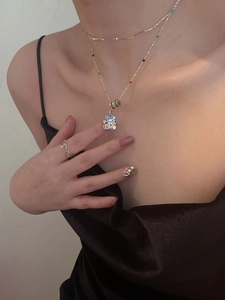 Detail of colorful enamel bear pendant necklace and silver choker on female model