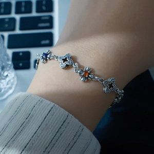 Bracelet trèfle en argent avec pierres de zircon colorées porté au poignet