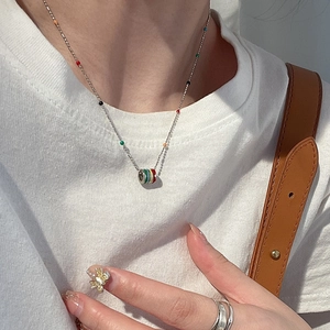 Rainbow enamel cylinder pendant necklace on a silver chain worn by a female model
