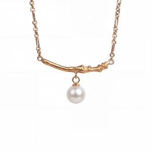 Detail of rose gold necklace with branch texture bar and hanging white round pearl charm