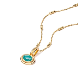 Detail of gold-plated necklace featuring a round turquoise stone set in circular pendants
