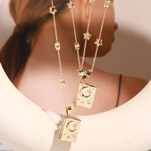 Gold celestial book locket necklace with engraved moon and stars on a dainty star chain