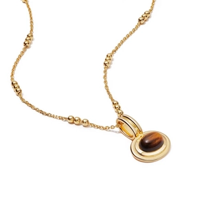Macro shot of gold layered necklace featuring an oval tiger eye gemstone pendant