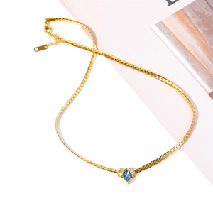 Dettaglio macro della collana a serpente dorata con zircone marquise blu e chiusura a moschettone