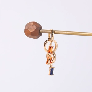 Elegant gold drop earrings with rectangular amber and navy stones on minimalist display
