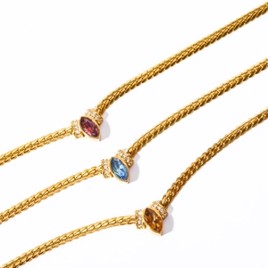 Dettaglio ravvicinato di tre catene a serpente dorate con zirconi colorati taglio marquise