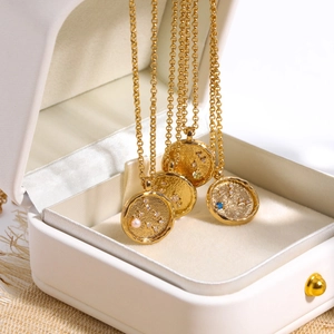 Detailed close-up of four gold 12 constellation coin pendants with inlaid crystals