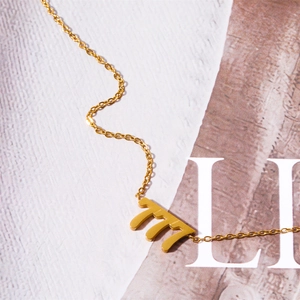 Macro shot of gold angel number 777 pendant on delicate stainless steel chain