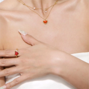 Detailansicht eines Modells mit roter Herz-Agat-Halskette und passendem Goldring-Set