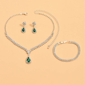 Detail view of bridal jewelry set with pear-cut emerald gemstones and pavé crystals