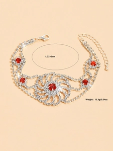 Détail d'une chevillère argentée avec cristaux rouges et fermoir mousqueton
