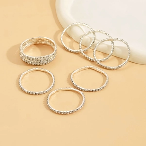 Macro view of silver elastic rhinestone rings set with white crystals on beige background