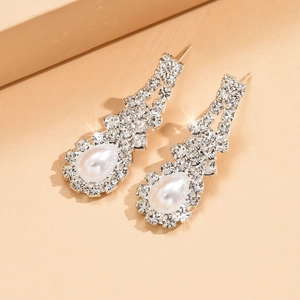 Orecchini da sposa argento con nappe, cristalli e perle a goccia su espositore elegante