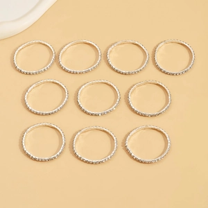 Flat lay of ten silver stretch bracelets with pavé set sparkling white rhinestones