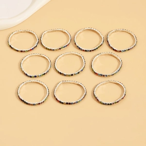 Close-up of 10-piece set colorful rhinestone stretch rings on a neutral background