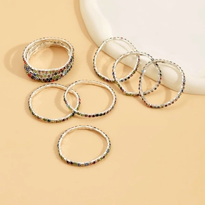 Detailed close-up of colorful rhinestone stretch bracelets on a white ceramic plate