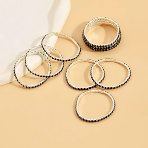 Detail of silver plated stretch bracelets with inlaid black rhinestones on a warm beige background