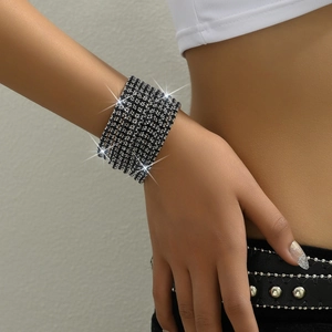 Detailed view of a wide multi-layer black rhinestone stretch bracelet on a female wrist