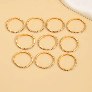 Macro detail of ten gold-tone elastic rings with sparkling pavé cubic zirconia crystals