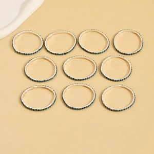 Set of ten silver bracelets with deep blue cubic zirconia crystals on a warm background