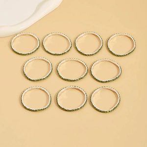 Close-up of 10-piece set featuring emerald green zircon crystals on silver bracelets