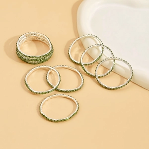 Detail of stretch rings featuring vibrant green zircons on polished silver metal bases