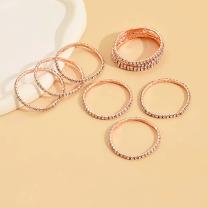Close-up of seven rose gold stretch rings set with sparkling clear zircon stones